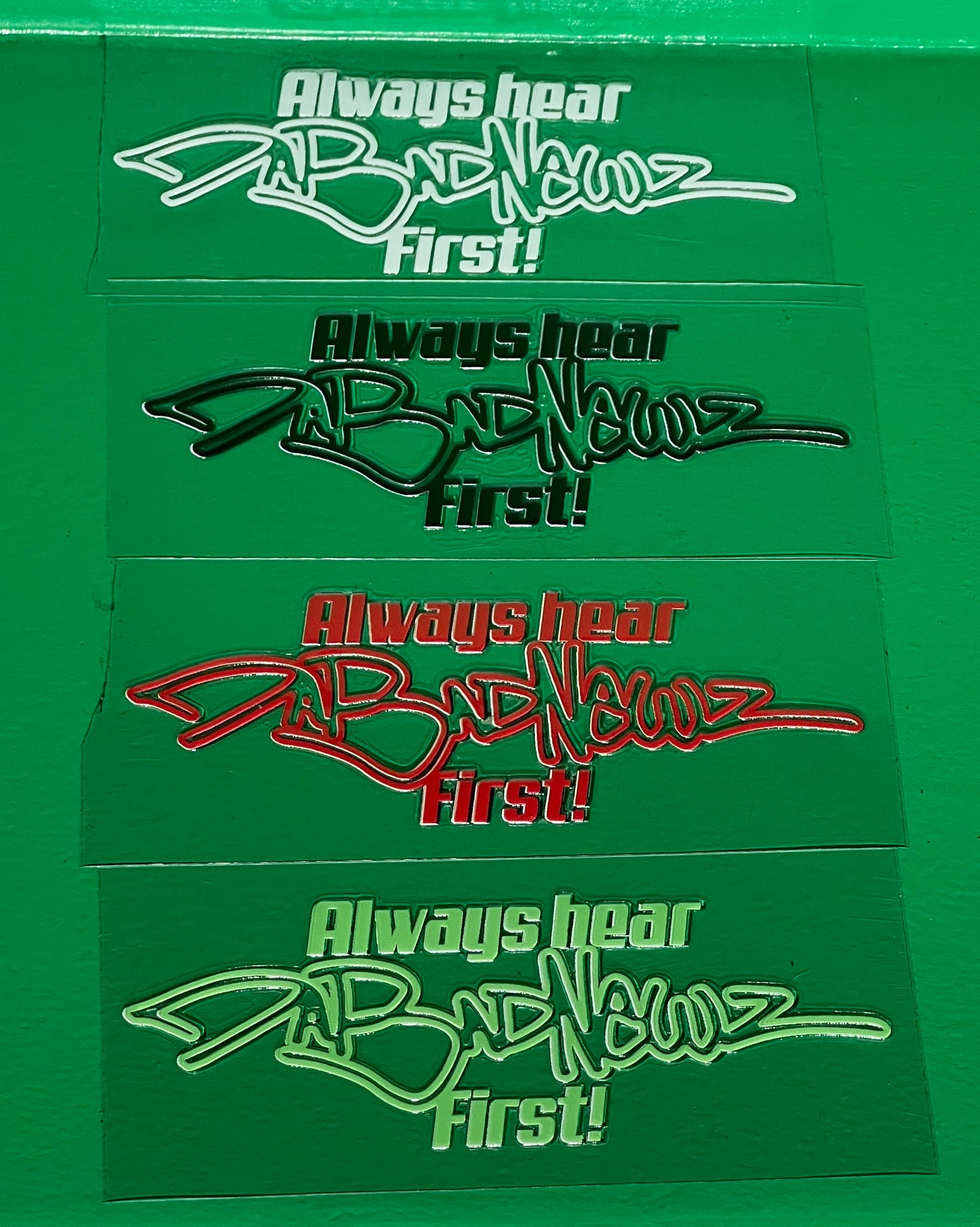 Four stickers with 'Always hear DaBadNewz First!' logo and text on a green background